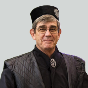 KTU Honorary Doctor Henry William Chesbrough following an honorary doctorate award ceremony. In the photograph, he is wearing academic ceremonial robes and a cap while looking towards the camera.