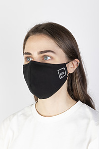 A dark-haired girl wearing a black fabric protective face mask with the KTU logo.