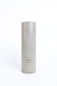 Roll-shaped gray concrete vase with a square KTU logo on the surface