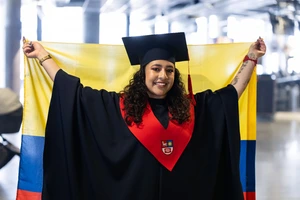 KTu graduate from Colombia, holding a Colombian flag