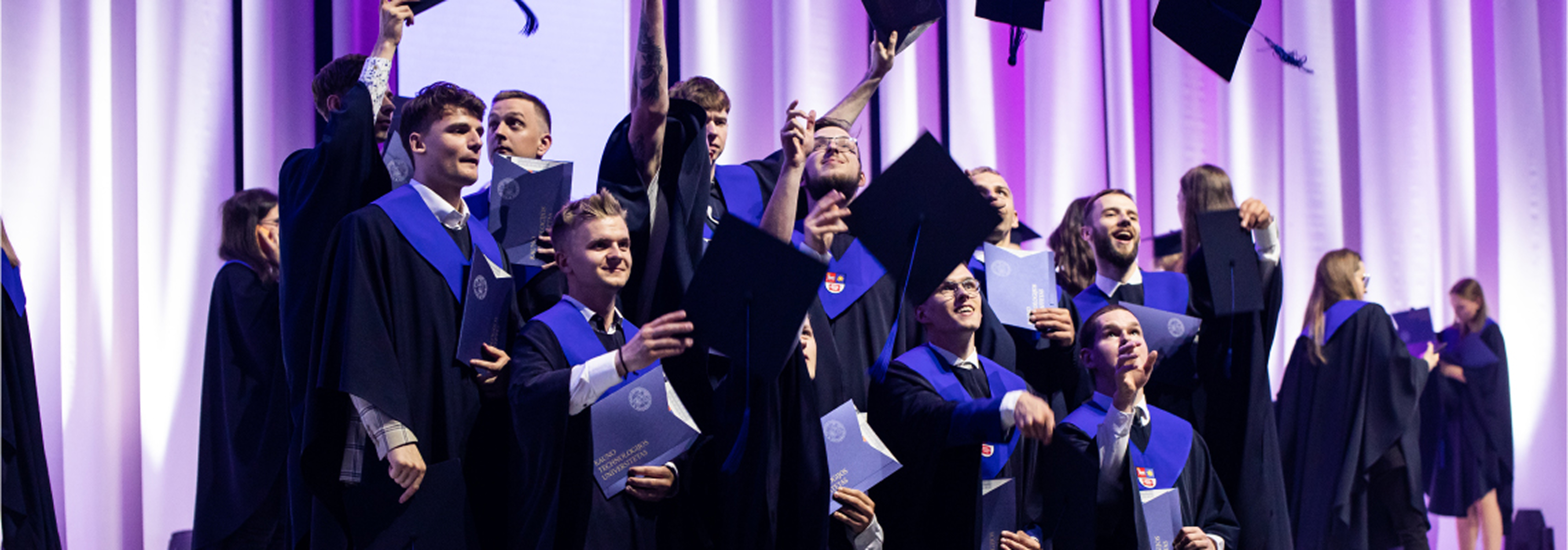 KTU graduates celebrating at a graduation ceremony, holding diplomas and tossing graduation caps into the air, representing the strategic direction &ldquo;Engaging Transformative and Empowering Learning for the Future&rdquo;.