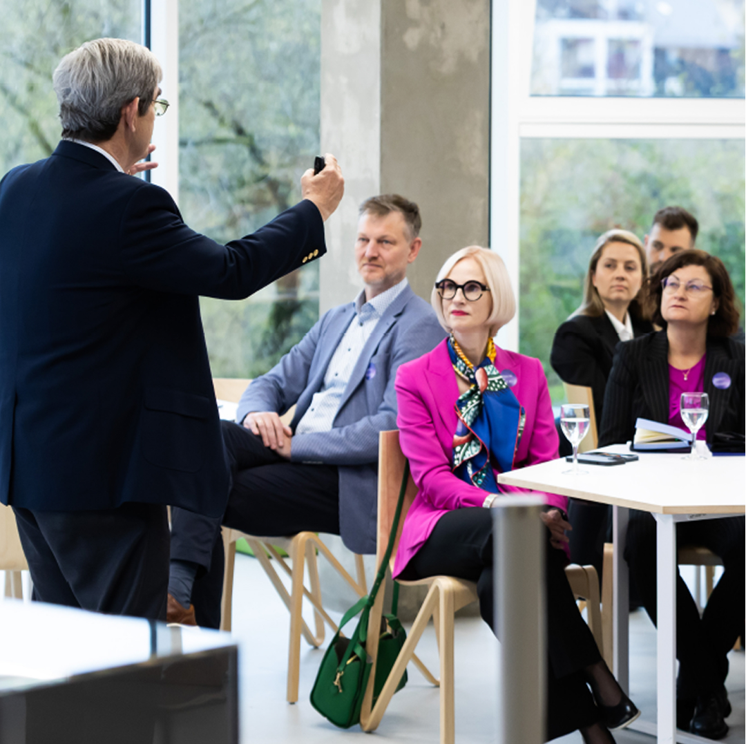 A speaker addressing an audience during a KTU event, with participants seated at tables in a university space, representing the strategic direction &ldquo;Impact on Ecosystems&rdquo;.