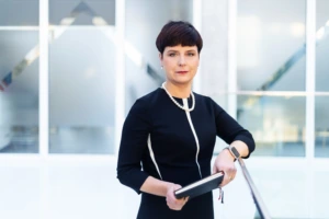 24-01-25 Edita Gimžauskienė 6 dark-haired woman dressed in black standing against grey background