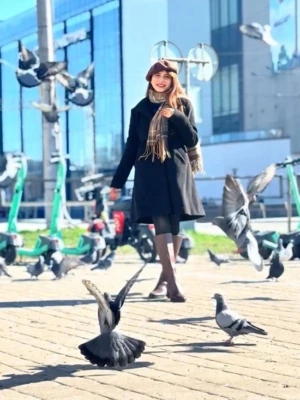 Photo, showing Umme in city square, birds flying around her